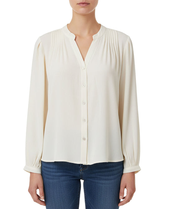 White blouse with long sleeves worn by a person on a white background